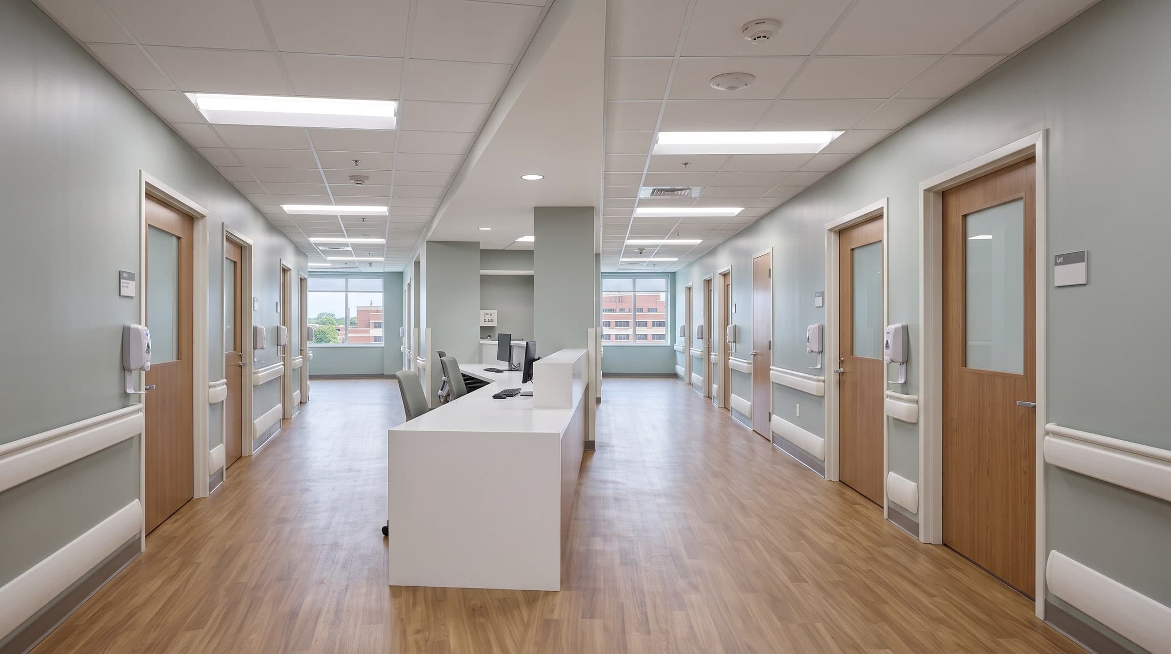The renovated patient floor: a bright corridor of patient room doors with handrails and a nurse station