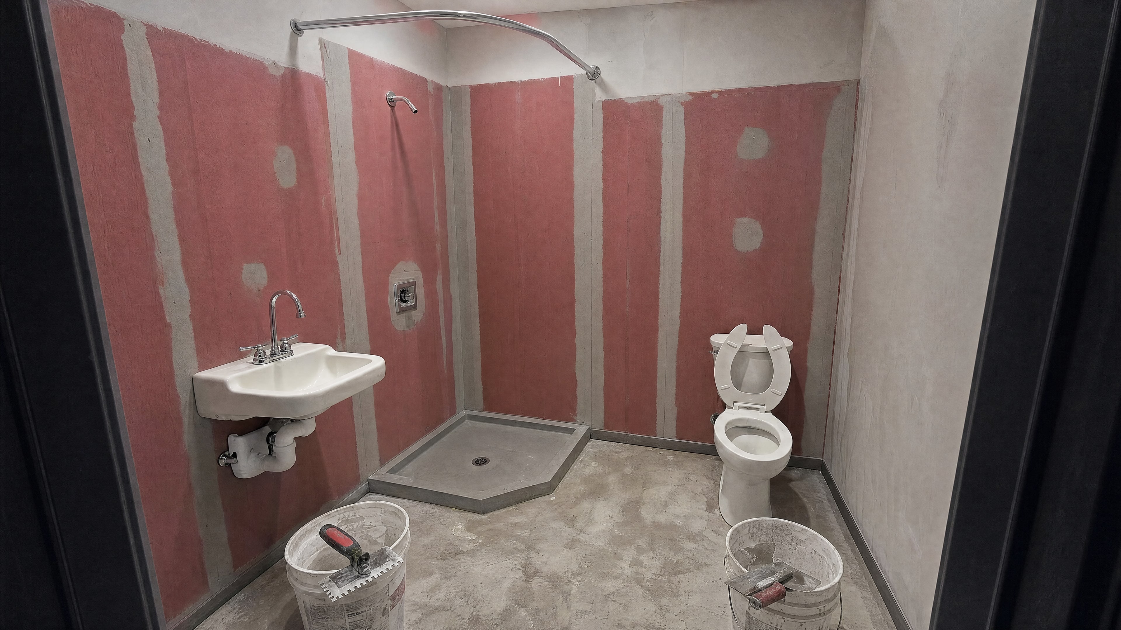 Cement backer board with a red waterproofing membrane and a new shower pan