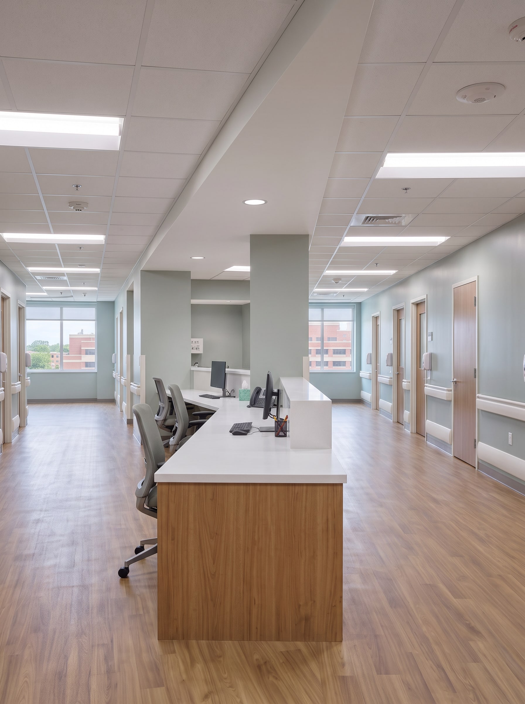 The nurse station: solid-surface counter, workstations and the corridor of patient rooms