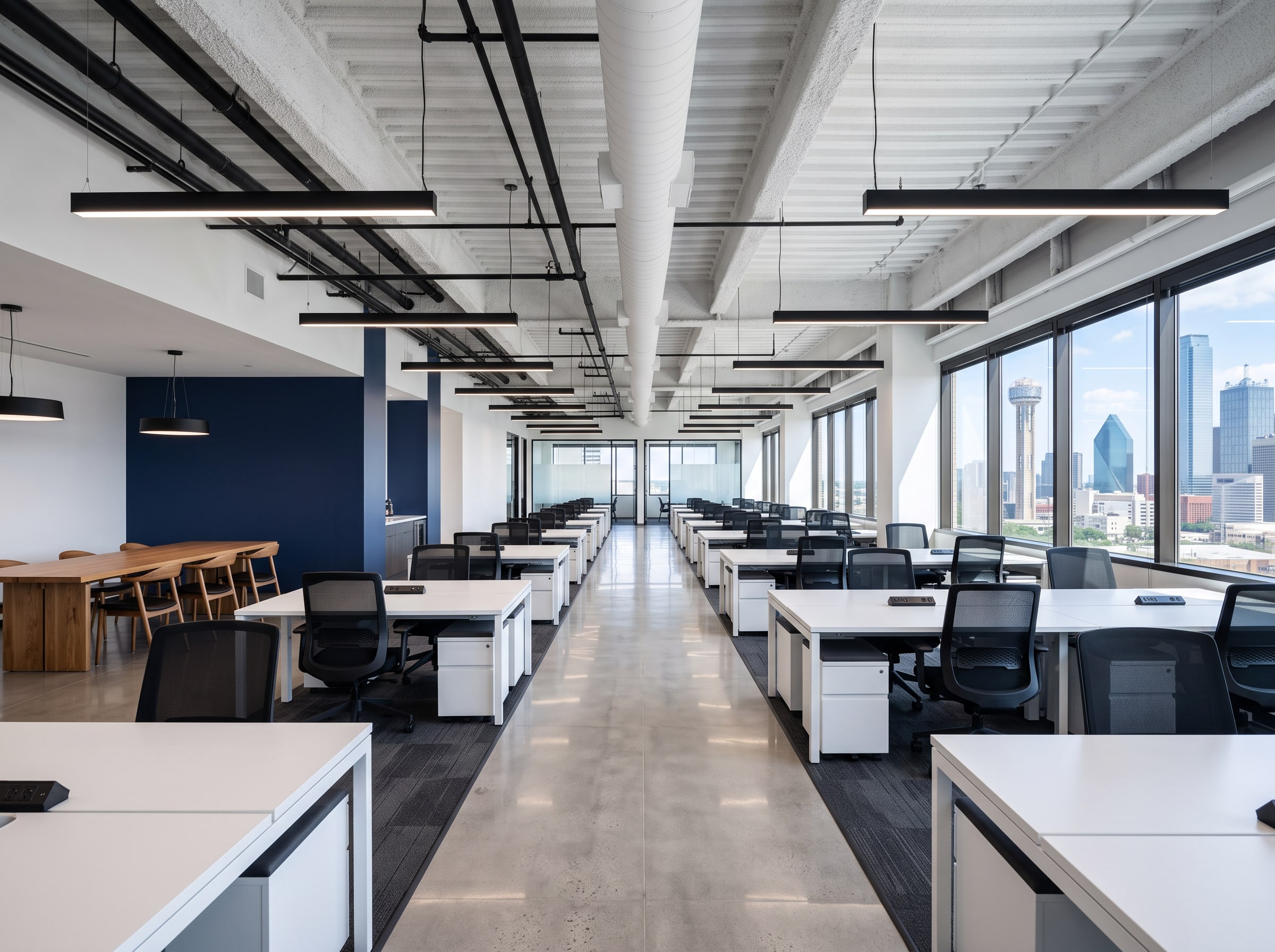 The same floor remodelled: open workspace, navy feature wall, new tile and carpet, pendant lights