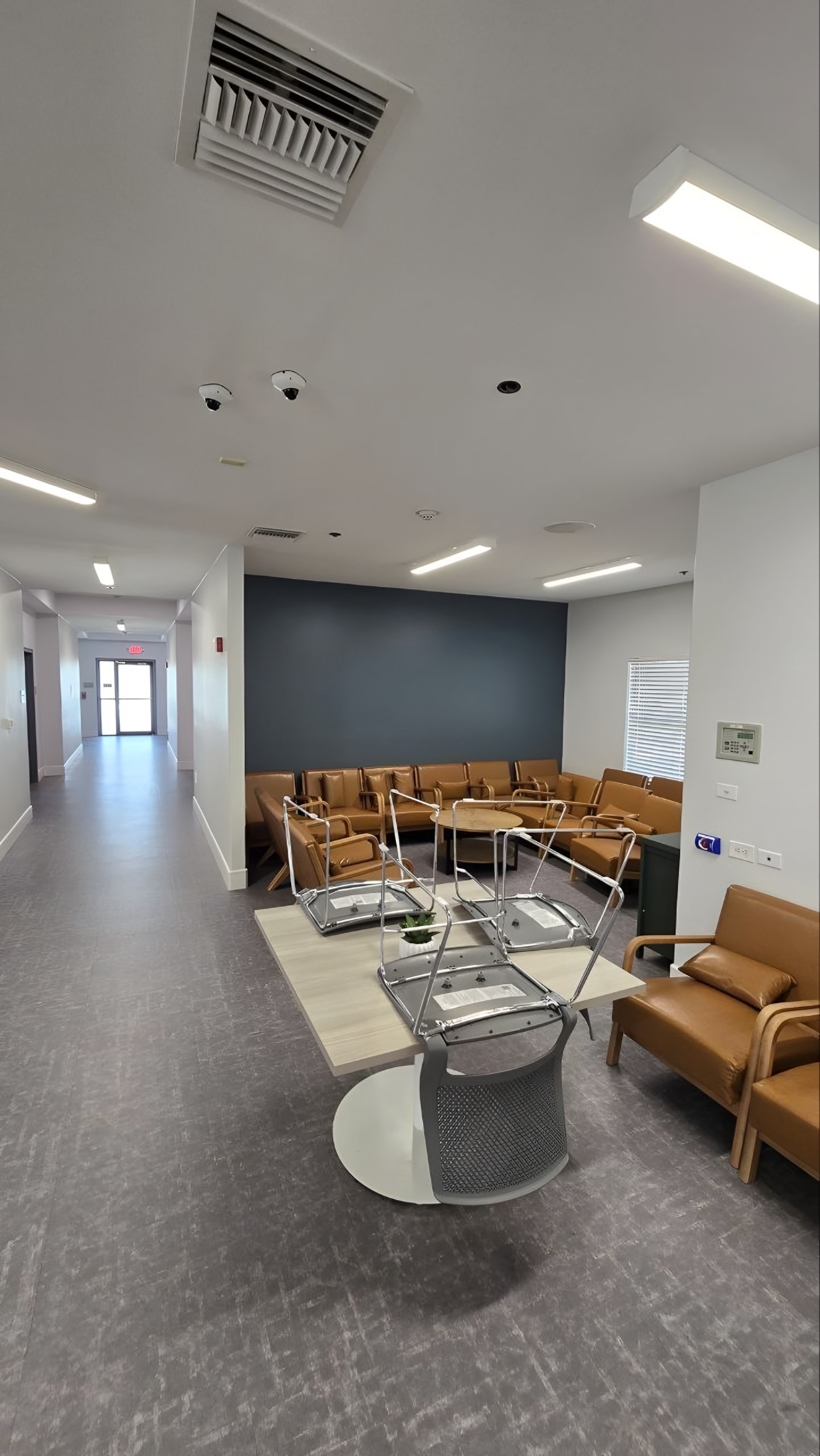 A finished lounge with leather chairs grouped beside a dark accent wall