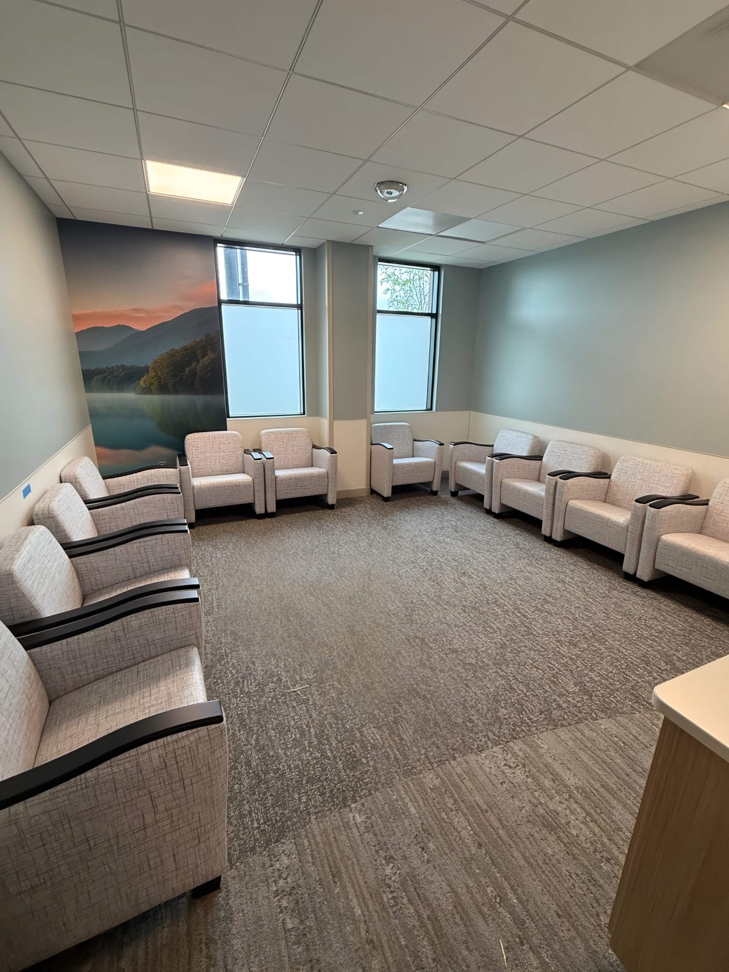 A finished waiting room with a printed mural wall and upholstered chairs