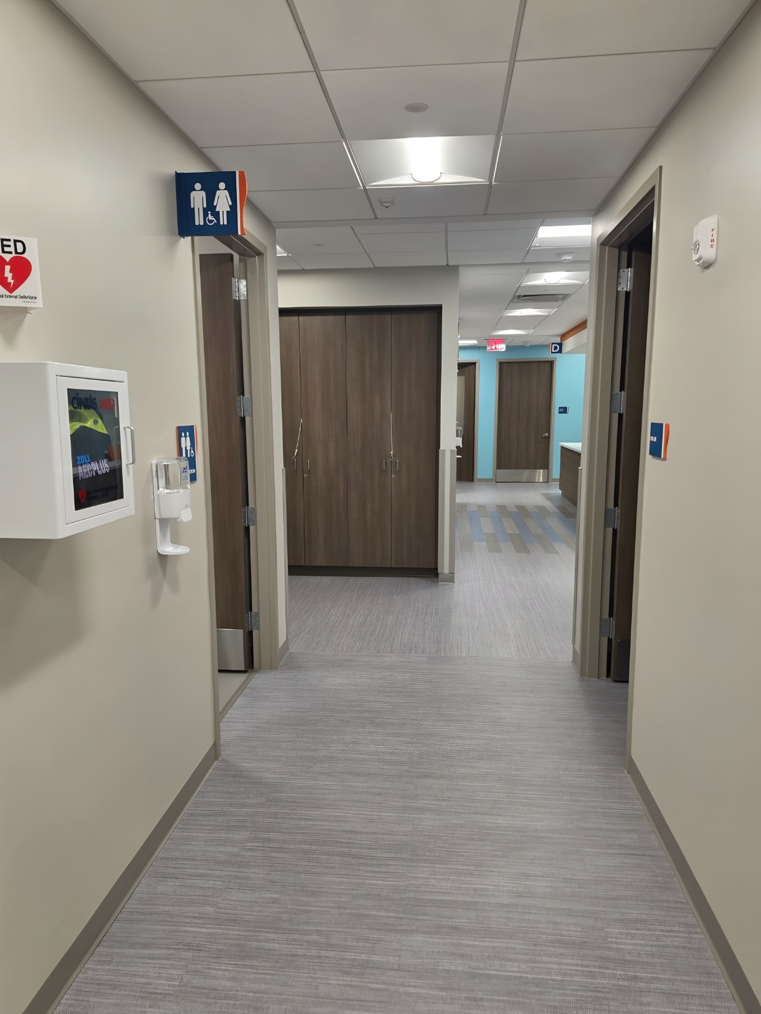 A corridor with painted accent walls and doors along one side