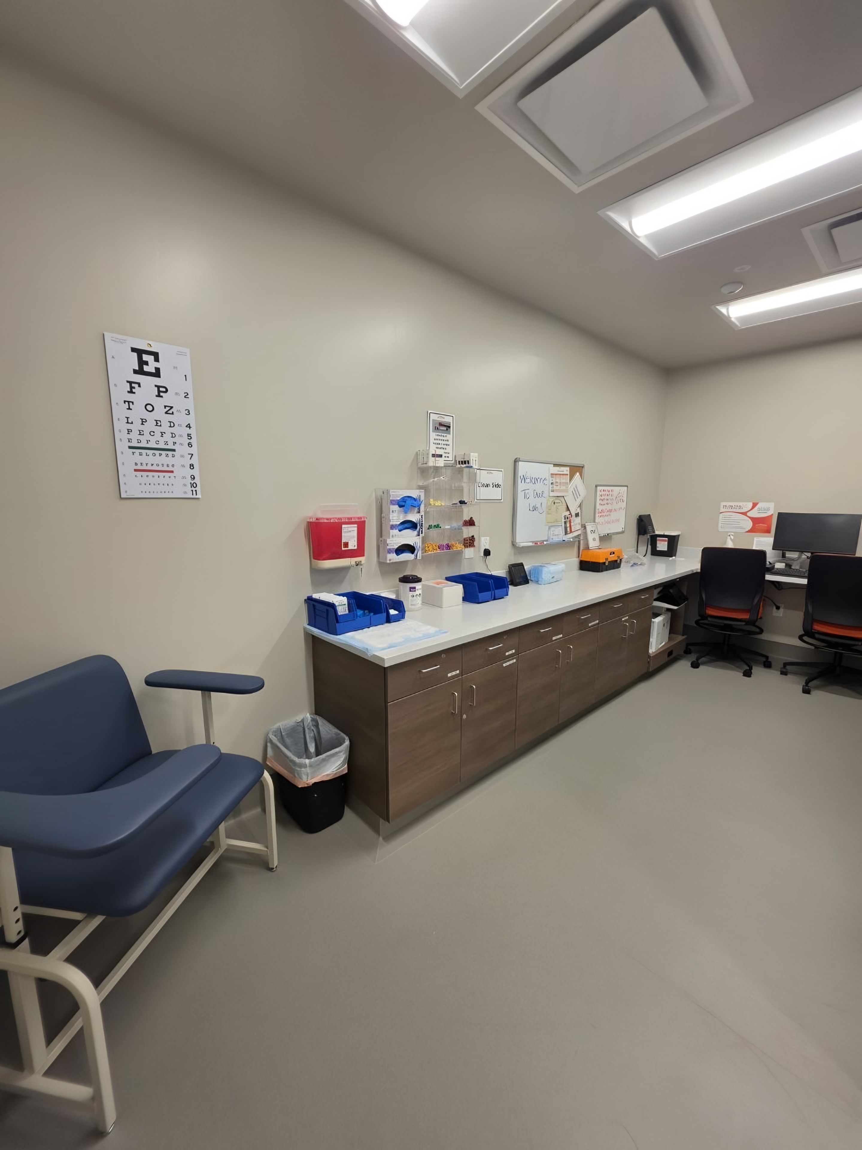 A finished clinical workroom with casework, a sink and a patient chair