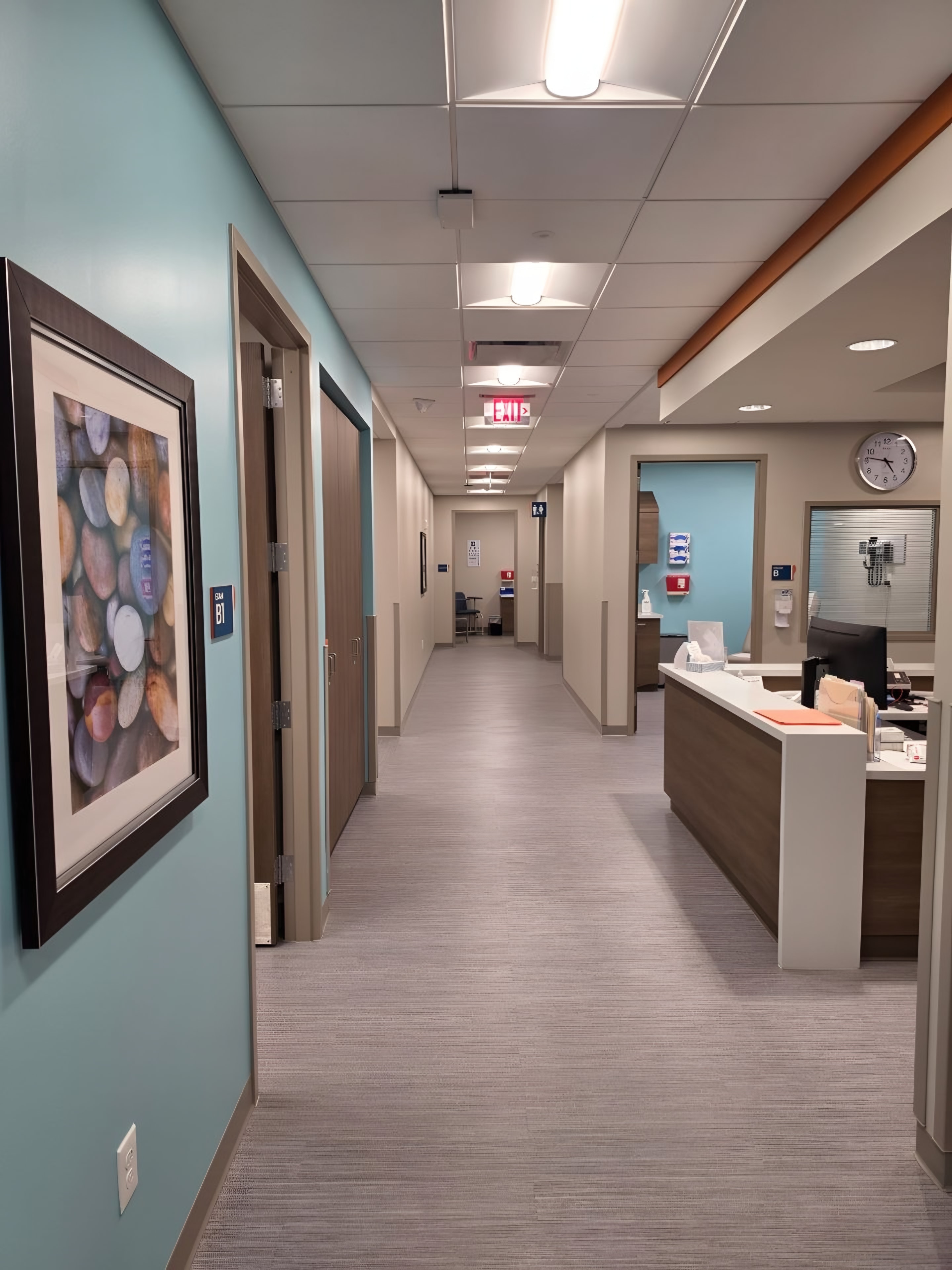 A corridor with a teal accent wall beside a staff station