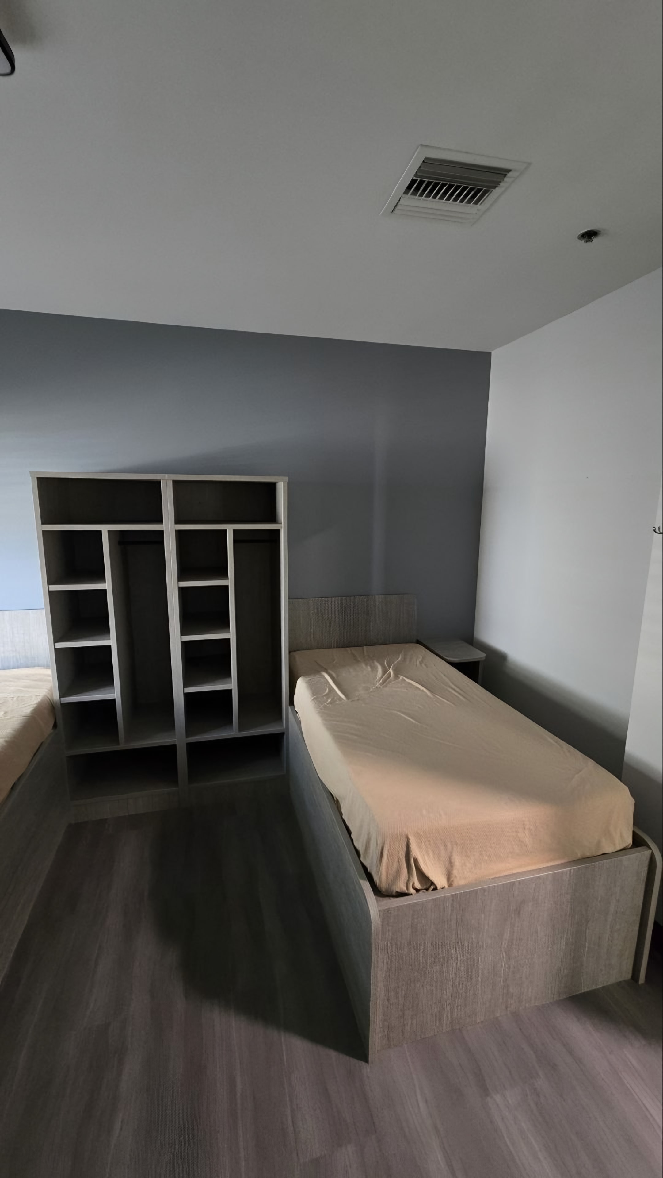 A finished resident bedroom with a platform bed and an open locker unit