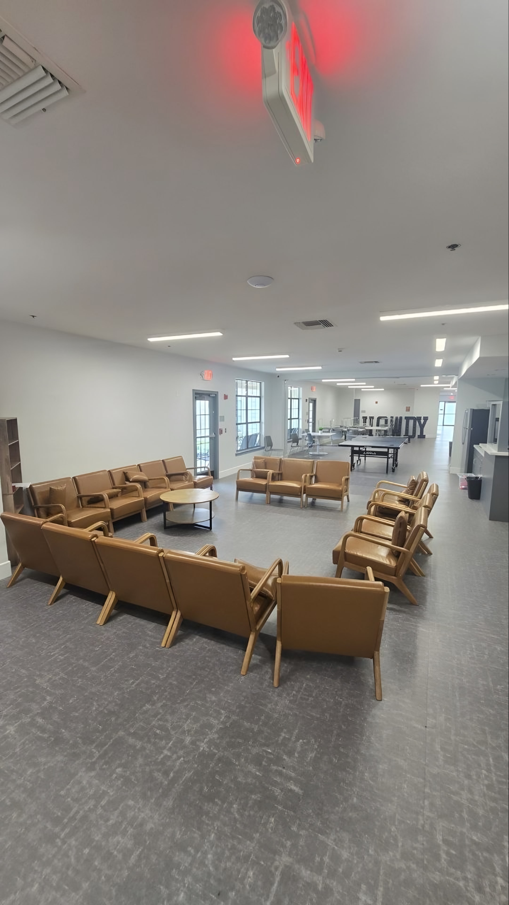 A finished dayroom with lounge seating and a coffee table
