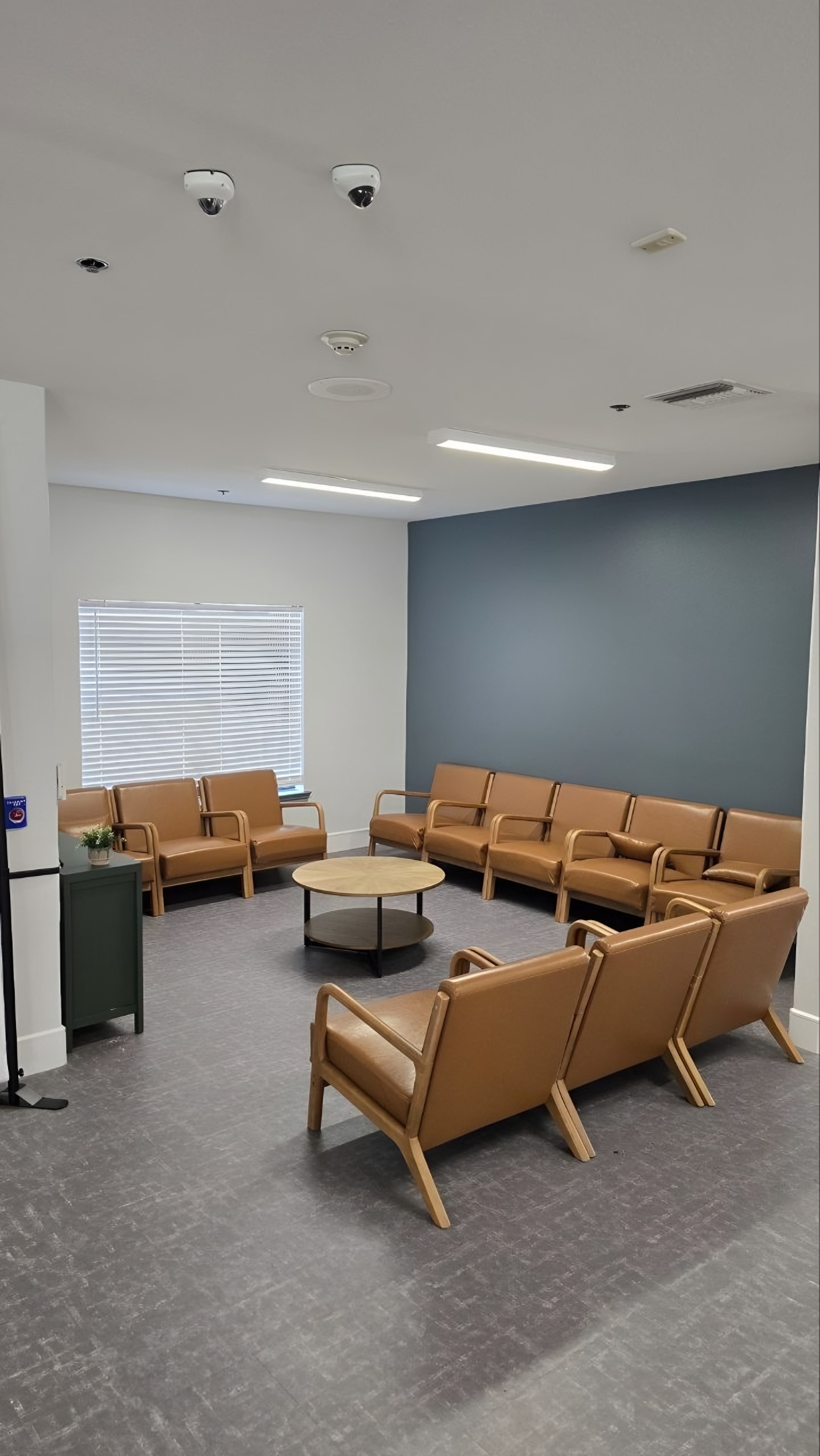 A finished lounge area with seating along a painted accent wall