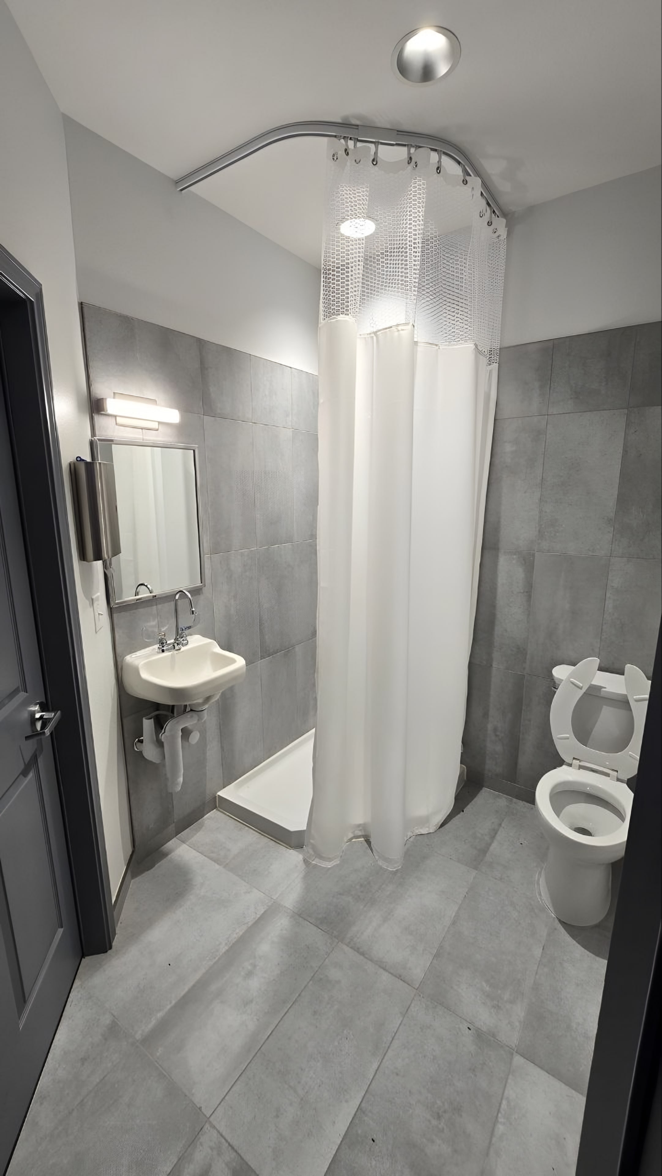 A wall-hung lavatory beside a curtained shower