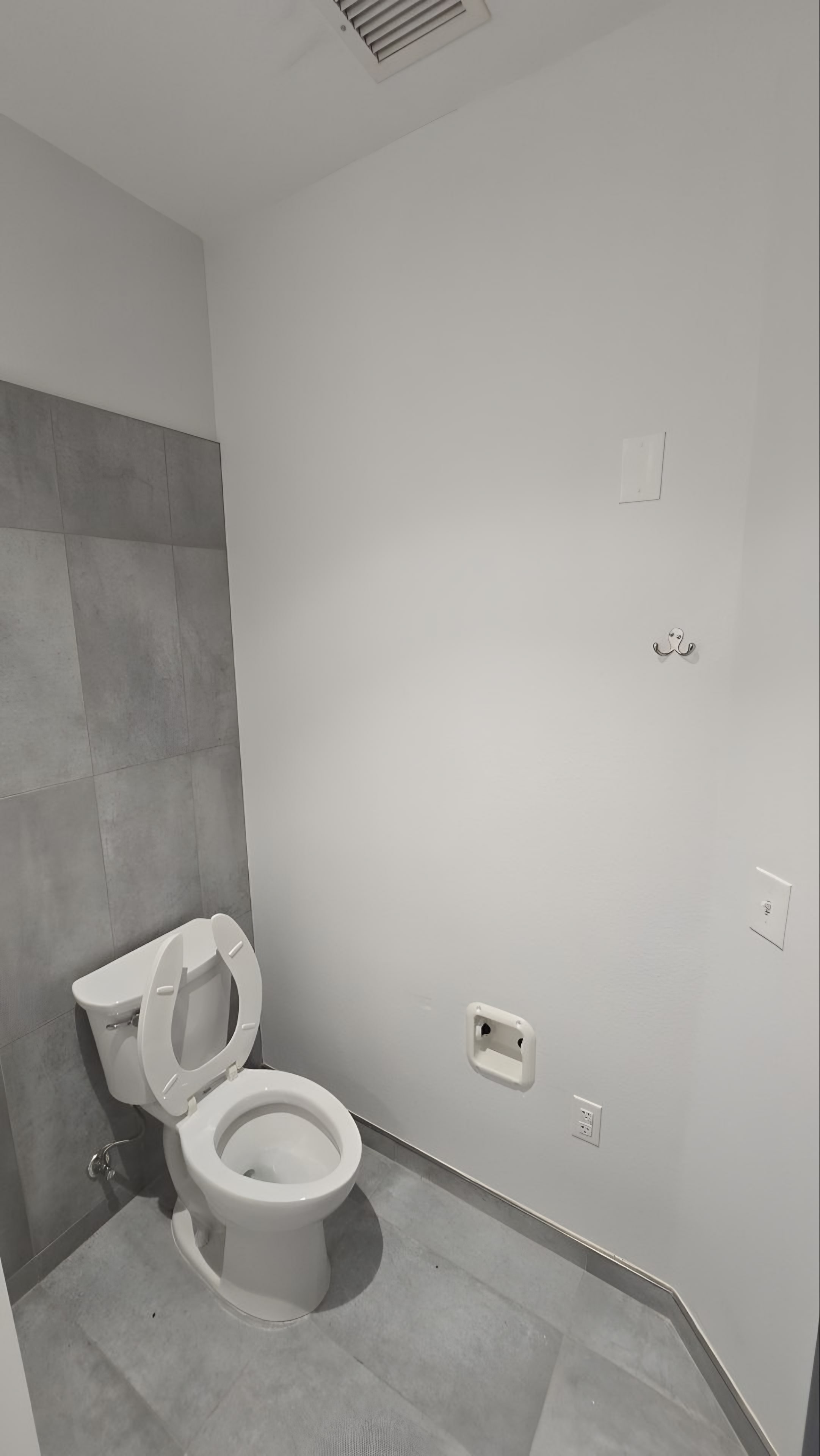 A shower room with grey wall tile